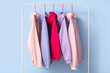© Pixel-Shot - Rack with colorful hoodies on blue background