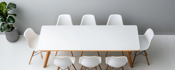 Poster - Modern dining table with white chairs and potted plant in minimalist setting, creating serene atmosphere
