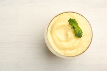 Wall Mural - tasty vanilla pudding with mint on white wooden table, top view. space for text