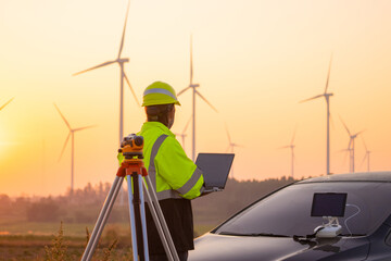 Aufkleber - Engineer working on laptop in front of wind turbines for checking wind turbines of the field during beautiful sunset. Alternative energy concept.