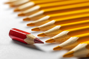 Poster - Close-up of red and yellow pencils, red pencil stands out from the row of yellow ones, symbolizing individuality, uniqueness, and standing out from the crowd