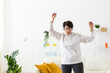 © satura_ - Joyful woman listening to music and dancing at home. Freedom, relaxation and happiness concept. Copy space
