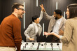 © BGStock72 - Joyful celebration among friends during a foosball game in a stylish indoor setting