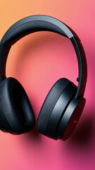 Poster - Modern black wireless headphones rotate, showcasing their design and features against a vibrant gradient backdrop, shifting from pink to orange