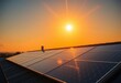© chanwut - Golden hour sunlight reflects off rooftop solar panels against a clear sunset sky, sun, orange
