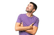 © luismolinero - Young handsome caucasian man over isolated background looking up while smiling