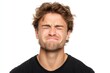 © Alive - Man grimacing in pain with squinted eyes against a white background