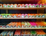 un estante lleno de sushi de colores arcoiris con diferentes formas y tama os variados presentaci n dise o comida