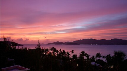 Poster - Captivating sunset displays glowing orange and pink hues over a calm tropical sea, silhouetted hills, and distant islands captured from an elevated cliffside