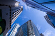 © ultramansk - Modern skyscrapers with reflective glass facades under a blue sky. Urban architecture, business district, financial center, corporate growth, and city development