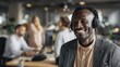 © romanets_v - African male adult smiling with headphones in modern office environment
