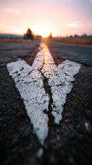 Poster - Close-up of worn white arrow painted on asphalt road, vanishing point perspective towards sunset, symbolizes journey, direction, future, progress
