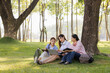 © Wanchai - A group of female students sits under a tree in the park, laughing and chatting joyfully together.