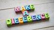 © Mirivox - Colorful wooden letter blocks spelling 'Make a Difference' on a light wood background, conveying a message of positive impact and social responsibility