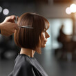 © Mselected - Woman getting a stylish bob haircut in a modern salon setting during daylight hours