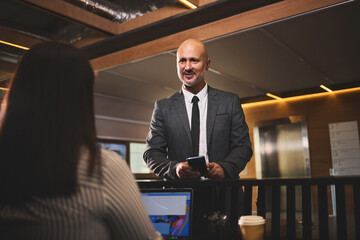 Poster - Businessman, reservation and receptionist with laptop, desk and hotel for meeting, travel and networking. Check in, hospitality and professional person in resort, registration and communication
