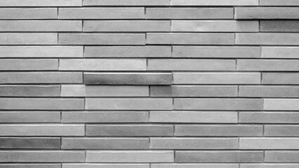 Aufkleber - A brick wall with a white brick in the middle. The wall is made of gray bricks and has a white brick in the middle. The white brick stands out against the gray background