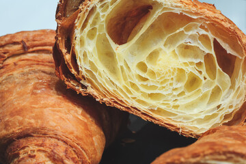 Poster - A croissant is cut in half, revealing its flaky, buttery layers. Concept of indulgence and luxury, as the croissant is a popular pastry often associated with high-end dining experiences