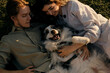 © Ekaterina - Young couple lying on the grass playing and cuddling with their happy Australian Shepherd dog. Aussie blue merle having fun outside with owners.