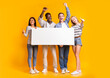 © Prostock-studio - Excited international group of teenagers holding empty white plackard, yellow background