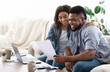 © Prostock-studio - Happy black couple managing family budget at home together, checking utility bills, copy space