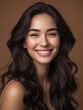 © Prime path 515 - Natural beauty portrait of smiling woman with long wavy brown hair and perfect skin on brown background, showcasing skincare and confidence in studio lighting
