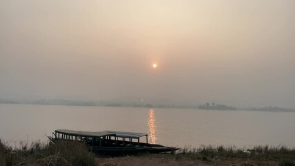 Sticker - The sun is setting over the lake.