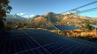 © efa - Solar panels in a scenic landscape with mountains and power lines under a clear sky