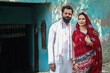 © GAJENDRRA BHATI  - Rural indian couple standing together looking at camera. Husband wife wearing kurta and sari. People of india.