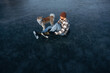 © standret - Be ready, preparing for the ride. Man with Akita Inu dog is on the ice with skates in winter