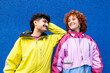© VISTA by Westend61 - Young friends in colorful urban clothing smiling against a blue background