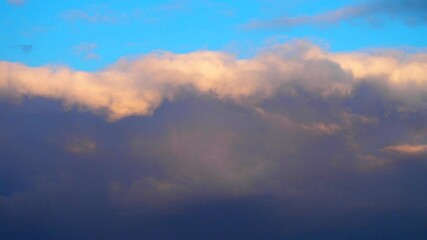 Poster - Majestic beauty of a large colorful moving cloud painted in shades of yellow, orange, pink, and blue against an enchanting sunset sky. Experience nature colorful masterpiece in motion.