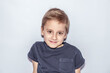 © Alina Lebed - Smiling child with light hair wearing a dark T-shirt, looking at the camera. The young boy has a relaxed posture, and his hand is slightly visible on his hip. The background is simple