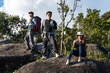 © Jack Tamrong - Group of Asian men and woman hikers with hiking pole reaching top of mountain