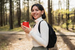 © Andrei - Woman hiker in casual gear sipping from a thermo mug in a peaceful forest, merging travel lifestyle with wellness vibes