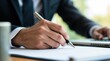 © Brutyse - Businessman writing and working on laptop at office desk