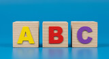 Wooden alphabet blocks abc on blue background representing early childhood learning and education