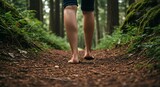 Bare feet walking on a forest path surrounded by green foliage and tall trees in a natural setting