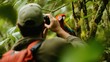 © Nur - Man taking a photo of a scarlet macaw in rainforest