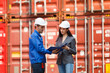© DG PhotoStock - Businesswoman and logistic or shipyard engineer have a discussion or business due at container yard.