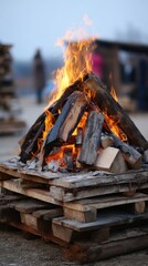 Poster - Captivating bonfire ablaze on rustic wooden pallets against a blurred outdoor background creating a warm and inviting atmosphere perfect for cozy evenings