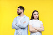© New Africa - Resentful couple with crossed arms on yellow background