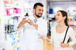 © JackF - Pharmacist advises customer in a pharmacy, offers medicine for body care