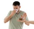 © Pixel-Shot - Sneezing young man and female hand with nuts on white background. Food Allergy Awareness Month