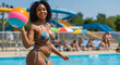 © Aline Shawn - Curvy woman in a floral bikini holding a colorful beach ball while standing by a pool. In the background, there are people lounging and swimming, and a large water slide is visible.