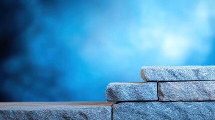 Poster - Close-up of stacked gray stones against a blurred blue background, creating a serene atmosphere
