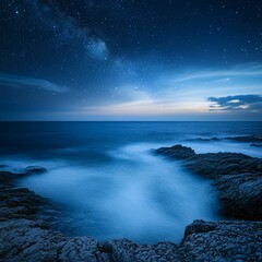 Poster - Rugged rocky beach captured at night with gentle waves and a starry sky creating a serene and tranquil coastal atmosphere