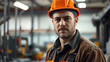 © Alexandra - Worker in safety helmet and industrial clothing inside factory environment with dramatic lighting and neutral background colors, focus on facial expression.