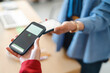 © Studio Marmellata - A customer is paying a vendor by tapping their phones together. This is a quick and easy way to transfer money.