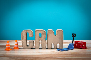 Wall Mural - CRM Concept. Concrete alphabet letters on a light painted wood texture background